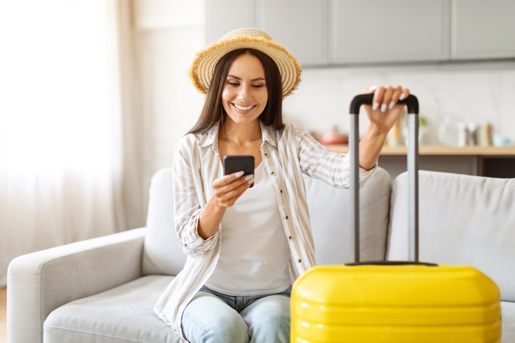 Smiling Young Woman Using Smartphone For Booking Vacation Online