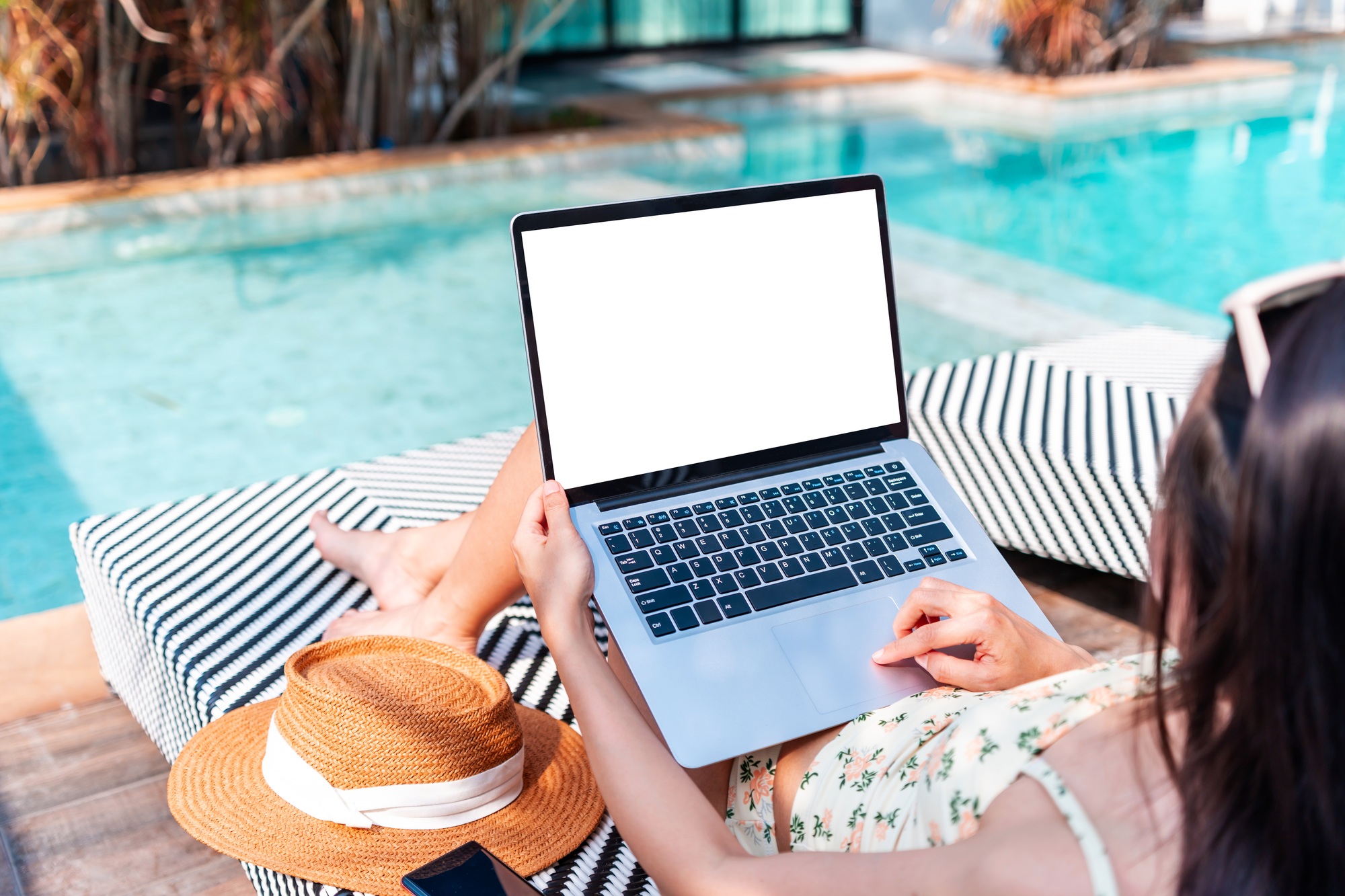 Young woman freelancer working online using laptop while traveling for summer vacation
